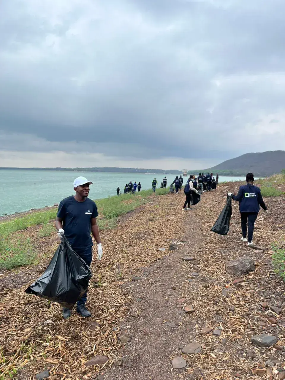 Scanlink team members participating in a lakeside waste clean-up